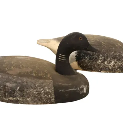 Sale Photo Thumbnail #83: Pair of vintage hand-carved wooden goose hunting decoys with weathered paint and glass eye details.