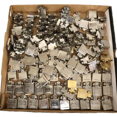 Sale Photo Thumbnail #196: Large cardboard tray filled with assorted metal lighter inserts, mostly silver-tone Zippo-style mechanisms with a few brass-toned pieces.