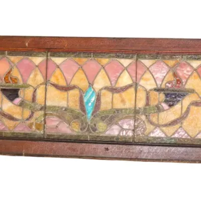 Sale Photo Thumbnail #255: Antique framed leaded stained glass transom window featuring a torch motif in shades of amber, pink, and green.