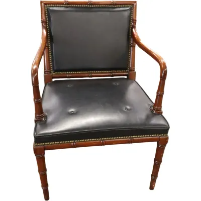 Sale Photo Thumbnail #270: Faux bamboo carved wooden armchair with black leather upholstery, brass nailhead trim, and tufted seat details.