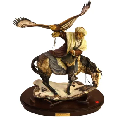 Sale Photo Thumbnail #59: RARE Bronn bisque porcelain detailed Giuseppe Armani sculpture titled 'The Wolfhunter,' depicting a horseman with an eagle on a wooden base.