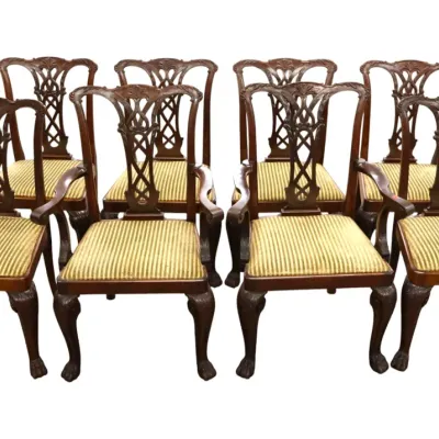 Sale Photo Thumbnail #272: Set of eight Chippendale-style mahogany dining chairs featuring ribbon-back splats, ball-and-claw feet, and striped upholstered seats.