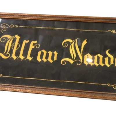 Sale Photo Thumbnail #137: Framed vintage embroidered or flocked velvet sign reading 'Altav Neade' in decorative Gothic lettering, housed in a thin wooden frame with glass.