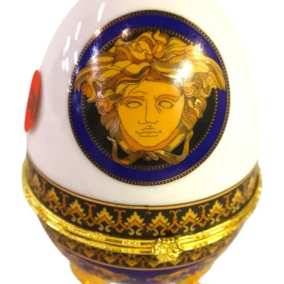 Sale Photo Thumbnail #9: Rosenthal Versace porcelain egg-shaped trinket box featuring a classic Medusa head logo with gilt trim and footed base.