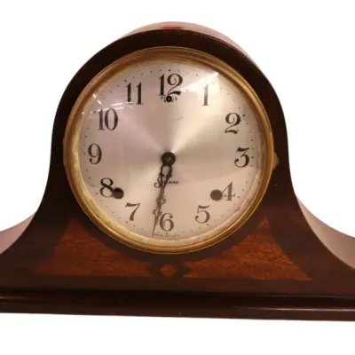 Sale Photo Thumbnail #121: Vintage Sessions mahogany tambour mantel clock featuring a brass bezel, silvered dial with Arabic numerals, and decorative wood inlay.