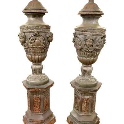 Sale Photo Thumbnail #44: Fantastic pair of ornate classical style covered urns on matching hexagonal pedestals, featuring raised cherub and head motifs in an antiqued bronze-tone finish.