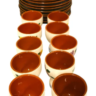 Sale Photo Thumbnail #279: Set of ten hand-painted terracotta egg cups with floral and fruit motifs, accompanied by a stack of matching small saucers.