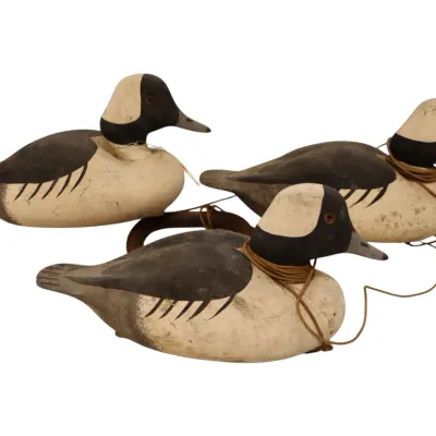 Sale Photo Thumbnail #92: Trio of vintage hand-carved and painted wooden bufflehead duck decoys with glass eyes and attached rigging line.