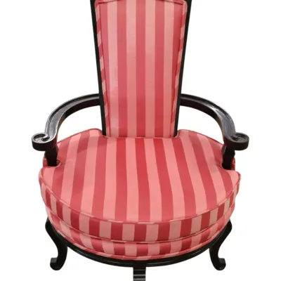 Sale Photo Thumbnail #271: Vintage high-back armchair featuring black painted wood frame with ornate carved crest and scrollwork, upholstered in red and pink striped fabric.