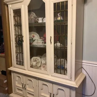 Sale Photo Thumbnail #13: Vintage white-painted French Provincial style hutch featuring glass display cabinet doors with decorative metal leaded grilles above a four-door base cabinet.