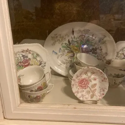 Sale Photo Thumbnail #12: Collection of vintage Spode fine china featuring floral patterns, teacups, saucers, and serving platters displayed inside a glass cabinet.