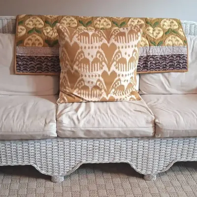 White Wicker Sofa with Cushions and Decorative Pillow