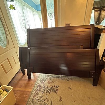 Sale Photo Thumbnail #72: Dark espresso wooden sleigh bed frame featuring a horizontal slatted headboard and matching footboard, displayed in an entryway.