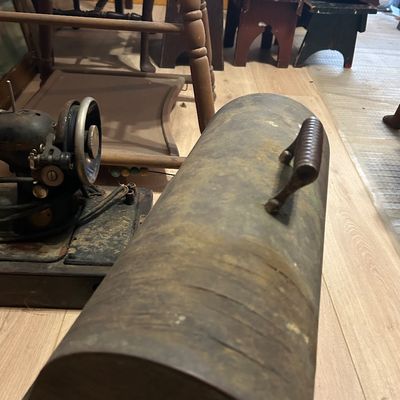 Sale Photo Thumbnail #23: Vintage metal bread box cover with a top handle, alongside an antique cast iron sewing machine and wooden furniture.