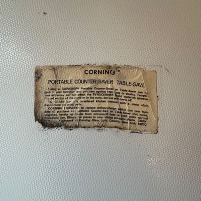 Sale Photo Thumbnail #83: Vintage Corning Pyroceram portable counter saver or table saver featuring the original manufacturer label on the textured glass surface.