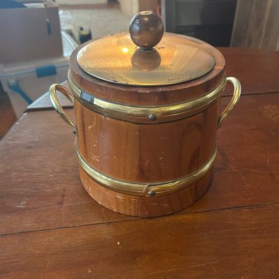 Sale Photo Thumbnail #62: Vintage wooden bucket-style ice chest with brass bands, side handles, and a brass lid topped with a round wooden knob.