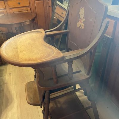 Sale Photo Thumbnail #8: Vintage wooden convertible high chair featuring a teddy bear graphic on the backrest and a tray that swings overhead.