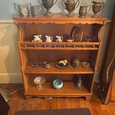 Sale Photo Thumbnail #2: Vintage wooden three-tier shelf filled with assorted collectibles, silver-tone urns, creamer pitchers, and glassware.