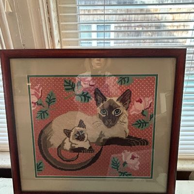 Sale Photo Thumbnail #75: Framed vintage needlepoint artwork depicting a Siamese cat and kitten surrounded by pink roses, set in a wooden frame under glass.