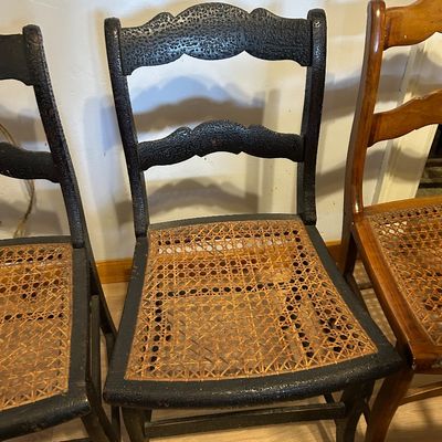 Sale Photo Thumbnail #106: Vintage ladderback dining chairs with hand-woven cane seats, including two with dark distressed paint finishes and one in natural wood.