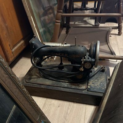 Sale Photo Thumbnail #24: Vintage electric Singer sewing machine in a wooden base, showing heavy surface wear and aging.