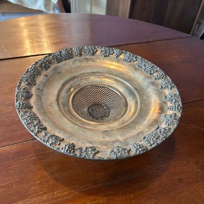 Sale Photo Thumbnail #92: Vintage silver-plated flower frog centerpiece bowl featuring an embossed grape and leaf border and a removable mesh insert.