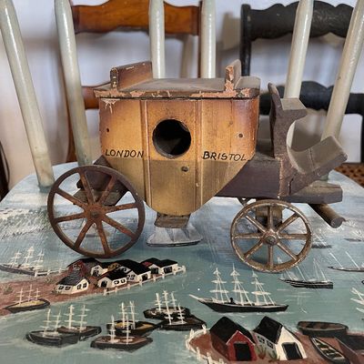 Sale Photo Thumbnail #13: Vintage handmade wooden stagecoach birdhouse marked 'London' and 'Bristol', featuring spoked metal wheels and rustic aged finish.