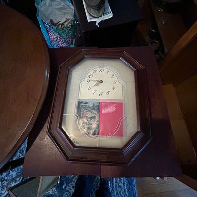 Sale Photo Thumbnail #44: Vintage octagonal wooden wall clock with glass front and decorative lower panel, shown lying on a tabletop.