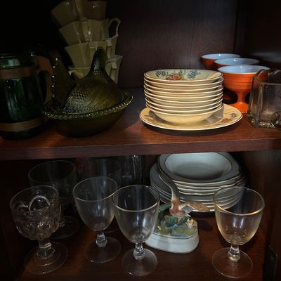 Sale Photo Thumbnail #55: Wooden hutch shelf containing vintage glassware, including a green glass hen on nest, stems, stacked floral bowls, and a small duck figurine.