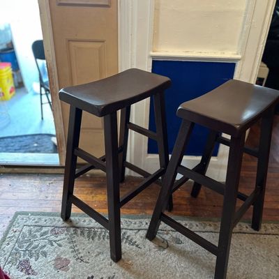Sale Photo Thumbnail #96: Pair of dark espresso wood saddle-seat barstools featuring built-in footrests.