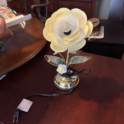 Sale Photo Thumbnail #29: Vintage flower-shaped accent lamp with cream-colored plastic petals, a polished brass base, and decorative glass leaves.