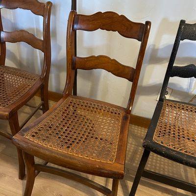 Sale Photo Thumbnail #104: Vintage ladder-back dining chairs with cane woven seats, showing visible wear and minor seat damage.