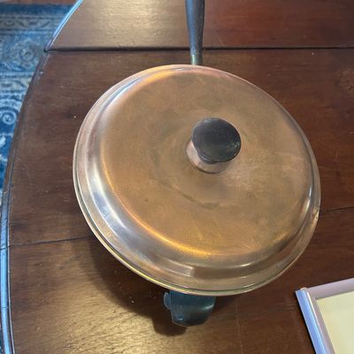 Sale Photo Thumbnail #63: Vintage copper chafing dish with a fitted lid, wooden handles, and a dark finished knob, set on a dark wood tabletop.