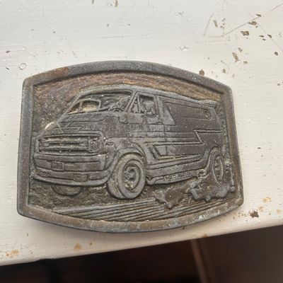 Sale Photo Thumbnail #71: Vintage 1970s brass or pewter belt buckle featuring a relief of a custom conversion van, showing heavy patina and age-related wear.