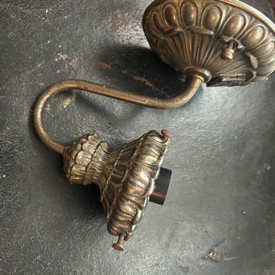 Sale Photo Thumbnail #70: Vintage brass wall sconce with ornate fluted detailing and a curved gooseneck arm.