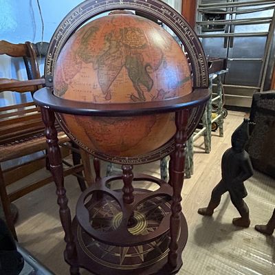 Sale Photo Thumbnail #108: Vintage Italian-style floor-standing globe bar cart with turned wood legs and a compass rose base, featuring an antique-style map design.