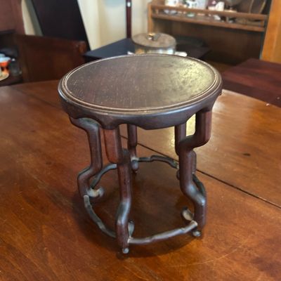 Sale Photo Thumbnail #69: Traditional Chinese carved dark wood display stand featuring a circular recessed top and intricate stylized legs.