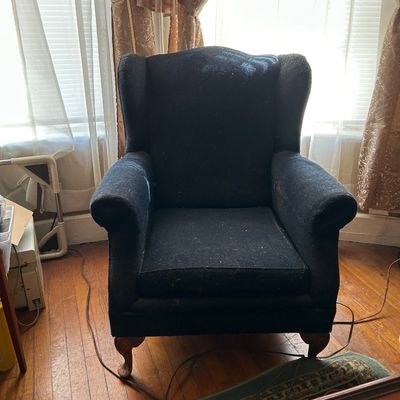 Sale Photo Thumbnail #113: Traditional dark navy blue upholstered wingback armchair with carved cabriole wooden front legs.
