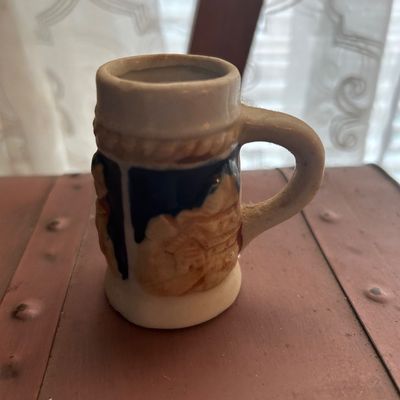 Sale Photo Thumbnail #68: Vintage miniature ceramic beer stein shot glass with raised relief village design.