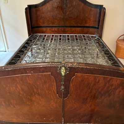Sale Photo Thumbnail #220: Antique French-style burl wood bed frame featuring intricate carved accents, ornate bronze mounts, and an exposed metal coil spring base.