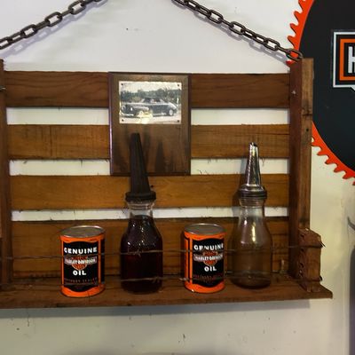 Sale Photo Thumbnail #169: Rustic hanging pallet wood display shelf featuring vintage Harley-Davidson oil cans and glass oil spout bottles.