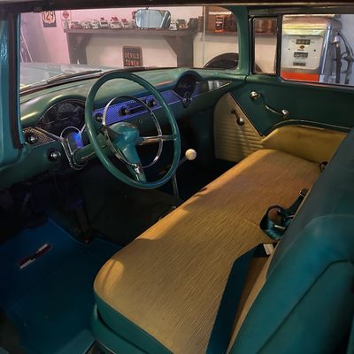 Sale Photo Thumbnail #67: Vintage 1950s Chevrolet Bel Air interior featuring a teal dashboard, matching steering wheel, and cloth front bench seat in well-maintained condition.