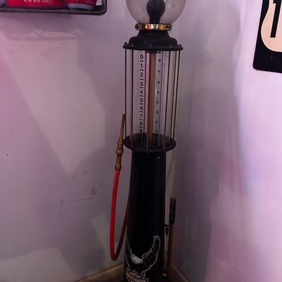 Sale Photo Thumbnail #173: Vintage-style replica Harley-Davidson visible gas pump with a clear glass cylinder, globe top, and red hose.