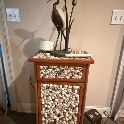 Sale Photo Thumbnail #235: Handcrafted wooden accent cabinet heavily encrusted with natural sea shells, topped with a vintage heron table lamp featuring cattail lights.