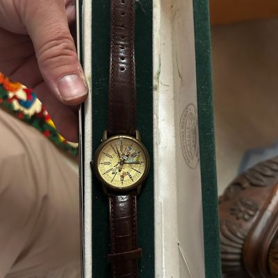 Sale Photo Thumbnail #139: Vintage novelty wristwatch featuring an illustrated dial and brown alligator-embossed leather strap, presented in its original velvet-lined display box.