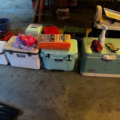 Sale Photo Thumbnail #76: Assortment of hard-sided coolers including Yeti, Coleman, and Engel brands, alongside microfiber towels and lawn maintenance tools.