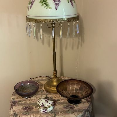Sale Photo Thumbnail #216: Vintage table lamp featuring a hand-painted floral glass shade with hanging crystal prisms, displayed alongside decorative glass bowls and a trinket box.