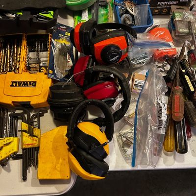 Sale Photo Thumbnail #15: Assortment of workshop items including multiple hearing protection earmuffs, drill bit sets, screwdrivers, and FrogTape.