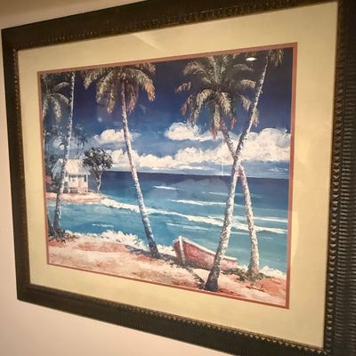 Sale Photo Thumbnail #232: Framed tropical beach landscape print depicting palm trees, a small boat, and a beach hut, presented in a dark, textured ornate frame with a wide mat.