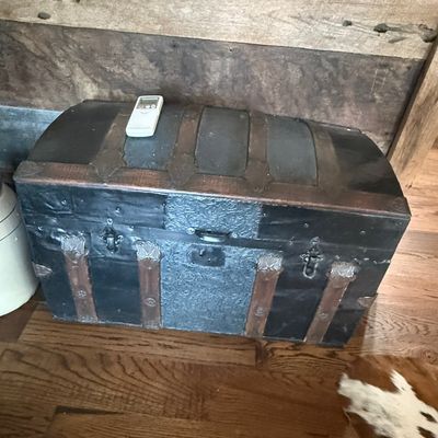 Sale Photo Thumbnail #250: Antique dome-top steamer trunk featuring embossed tin panels, wooden bands, and metal hardware.